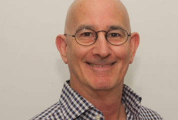 Image of scholar Benjy Maor wearing glasses and a checkered button up shirt.